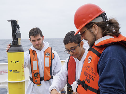 Jon Sharp, Elijah Catalan, and Brendan Carter stand next to a PMEL Biogeochemical Argo float