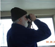 Image of scientist observing birds from the bridge.