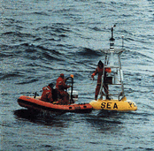 Scientists at sea, working on a surface mooring.