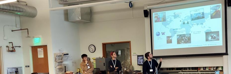 Three GOBOP members giving a talk in a classroom, looking at large projection screen