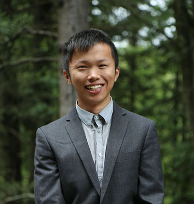 Headshot of Yang Xiang in front of forest