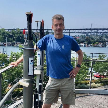 Hartmut Frenzel posing near water in front of a bridge