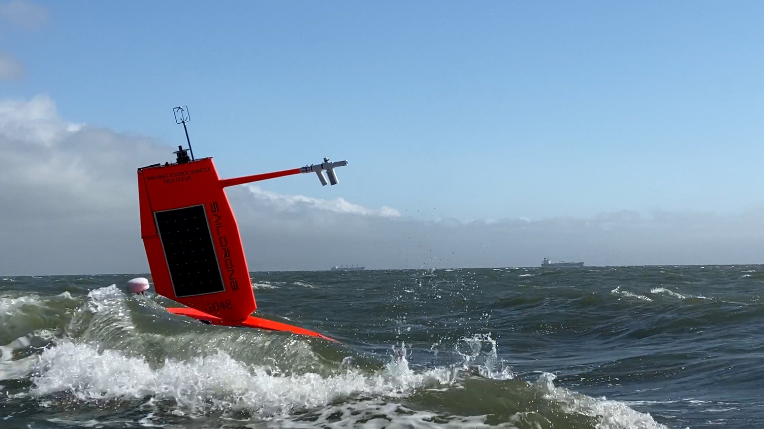 A saildrone cutting through a wave