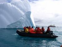 photo of a boat approaching an iceberg in Antarctica
