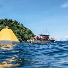 Buoy in Fagatele Bay in the NOAA National Marine Sanctuary of American Samoa with partner ship in the background.. 