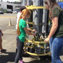 Middle school students taking samples from a CTD Rosette during camp