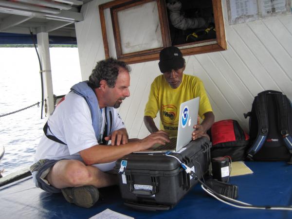 Scientist working on laptop aboard ship