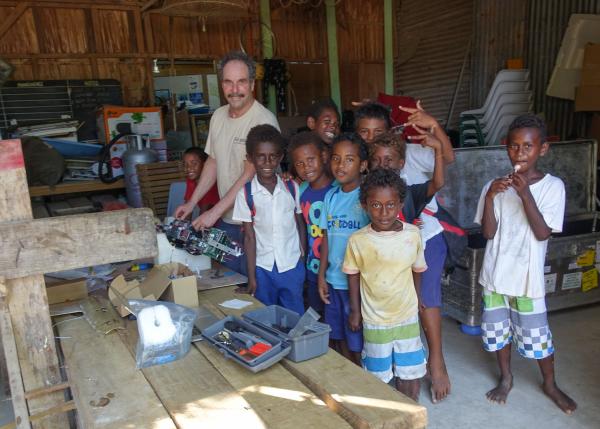 Local boys gather to watch researcher work on a glider