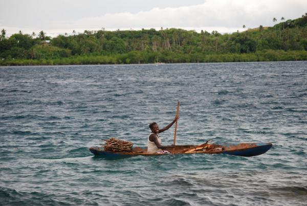 Woman leaving Gizo market in hand-carved canoe