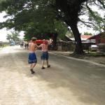 Two researchers carrying a glider across the main road in Gizo