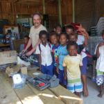 Local boys gather to watch researcher work on a glider