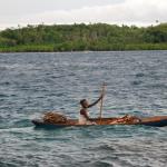 Woman leaving Gizo market in hand-carved canoe